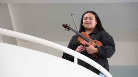 Anne Filimoehala holding a violin