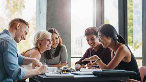 Students happily working together at a table.