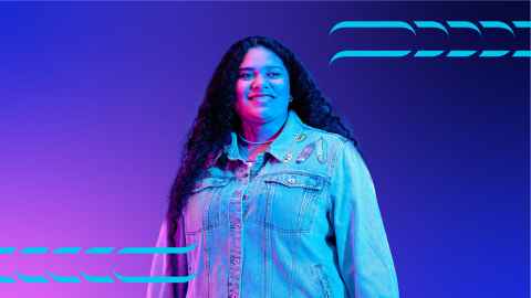 Student standing against a pink and blue background.