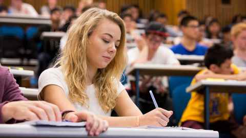 Students around a table reading.