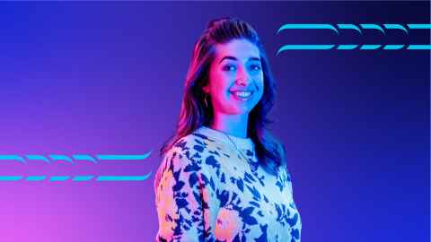 Student standing against a pink and blue background.