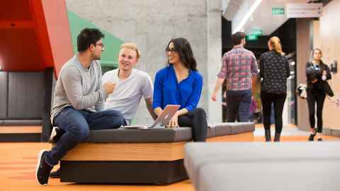 Group of three students in friendly discussion