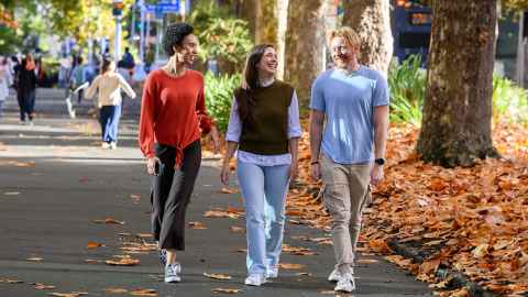 Group of happy students walking together outside