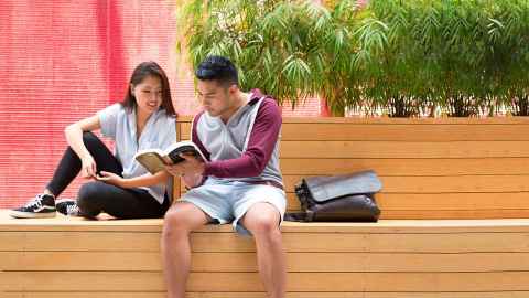 Students reading on a campus bench