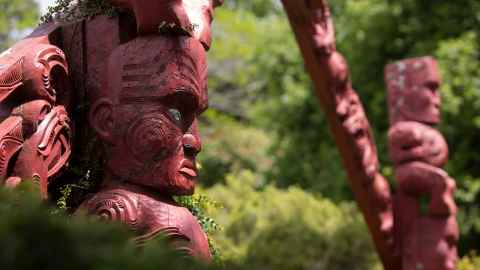 Maori carvings against a background of trees
