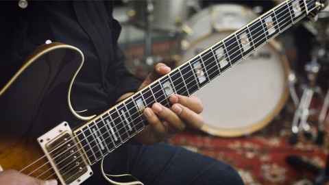 A hand playing an electric guitar