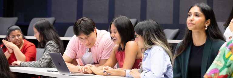 Group of six students sitting in a lecture theatre.