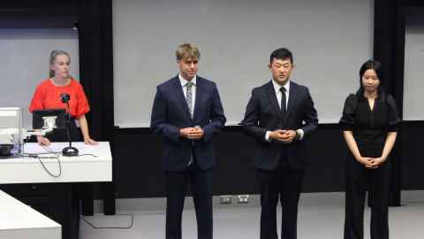 Four students standing at the front of a room giving their case presentation