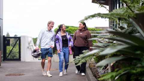 Three Engineering students walking outside.