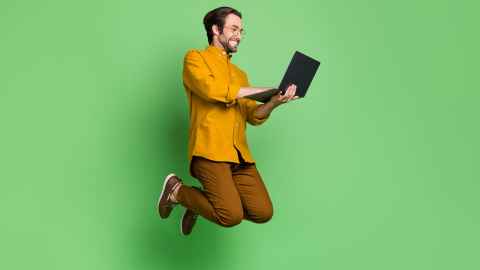 Student jumping with laptop