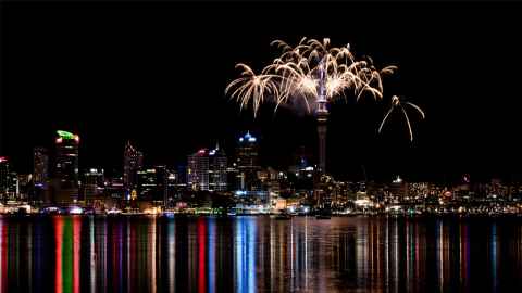 Photo of the Auckland skyline at night with fireworks coming from the iconic Skytower building.