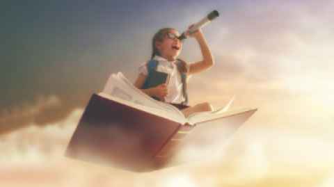 Young girl sitting on an open book that is flying through clouds, using a telescope with an excited expression