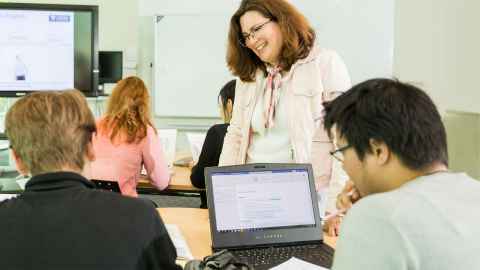 Students and teacher at laptop