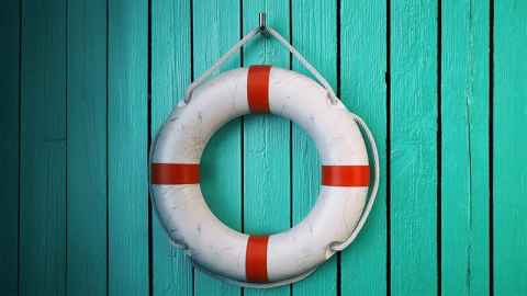 A life preserver hung up on a blue wall