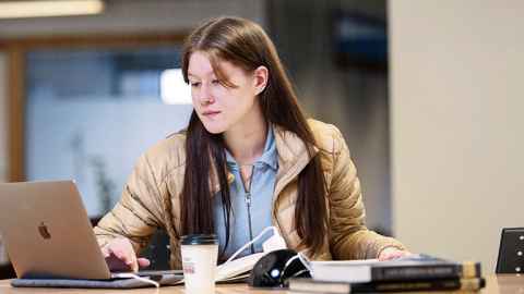 female student using laptop in library