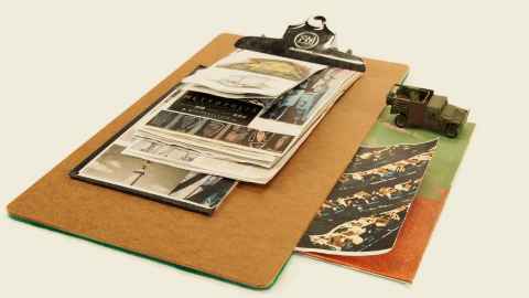 Photographs and other documents on a clipboard