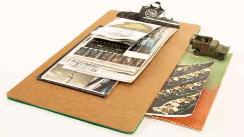 Photographs, documents on a clipboard, and miniature jeep. "Untitled Artists' Book" by Simon Esling, 2009.