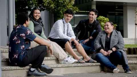 Group of students sitting on steps chatting