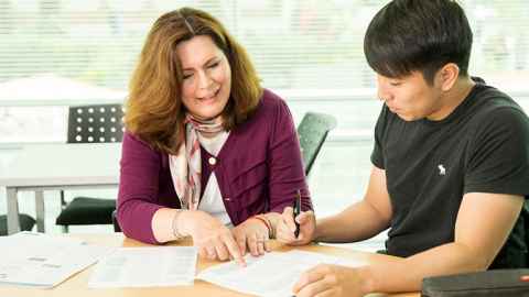 woman helping a male student with his English