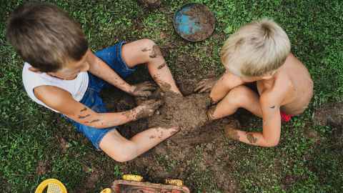 Children playing in the mud with toys