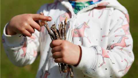 child holding sticks