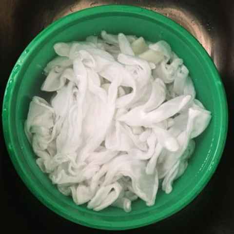 Green bucket full of white cotton gloves