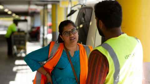 Two people in high-vis, talking.
