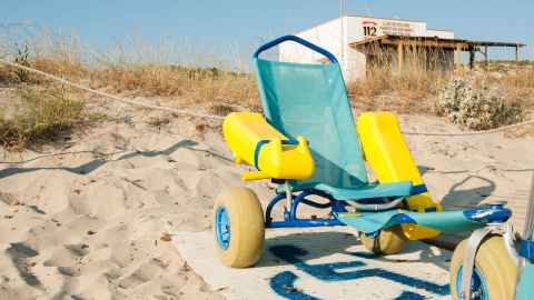 Wheelchair designed for beach, on a sandy beach on a sunny day 