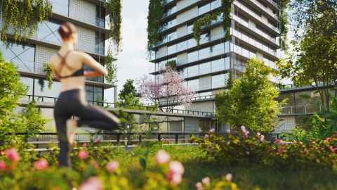 Woman doing yoga outside a green apartment