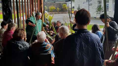 Group of people weaving harakeke outside a marae on City Campus.