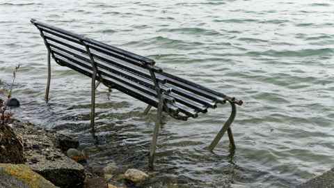 Park bench submerged by a rising tide