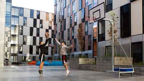 Two students playing basketball in the Carlaw Park - Nicholls courtyard