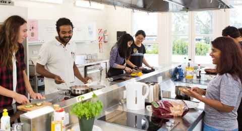 Group of people cooking in Grafton Student Flats' shared kitchen.