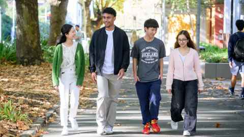 Group of happy students walking together outside