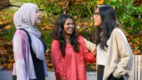 Trio of international students chatting outdoors