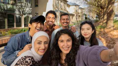 Group of six international students smiling into the camera