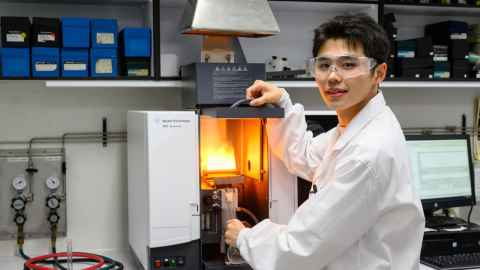 Zhen Zhang is working on machinery in a chemistry lab