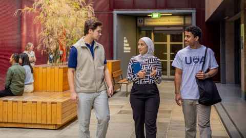 Group of 3 international students walking and chatting