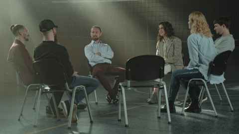 A group of people sitting in a circle, talking.