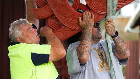 Master carver Arekatera (Katz) Maihi, Ngāti Whātua Ōrākei and Ngāpuhi (right), with Keith Walker (left), builder of Tāne-nui-a-rangi in 1987, together positioning the new maihi on Tāne-nui-a-rangi in 2024.